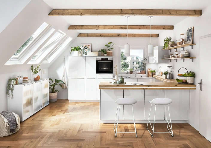 Cuisine moderne et lumineuse avec puits de lumière, poutres en bois et placards blancs. Cuisine moderne et lumineuse avec puits de lumière, poutres en bois et placards blancs.